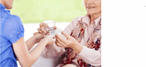 care home staff giving a resident their medicine